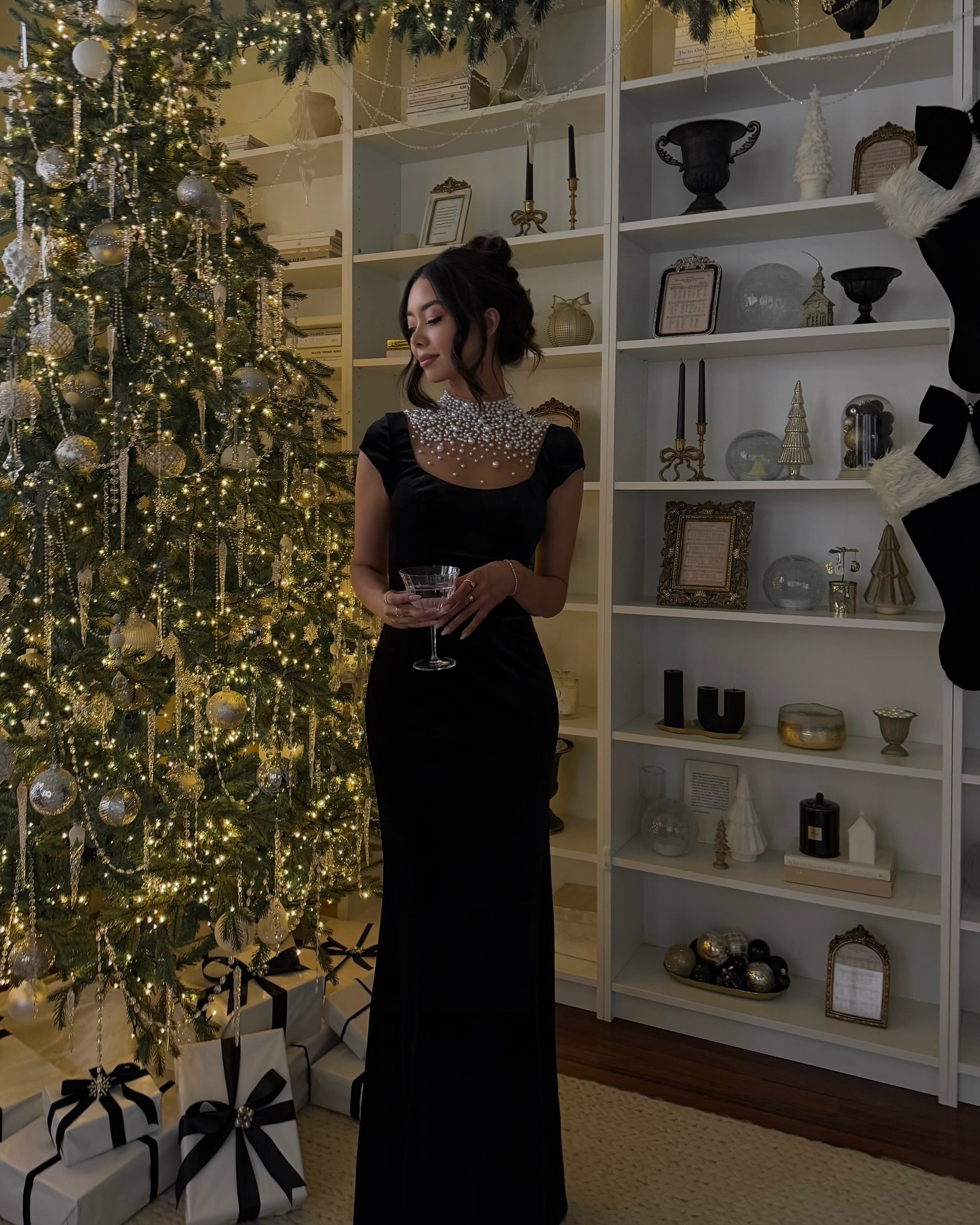 Black maxi dress with pearl-embellished neckline for an elegant Christmas Eve dinner.