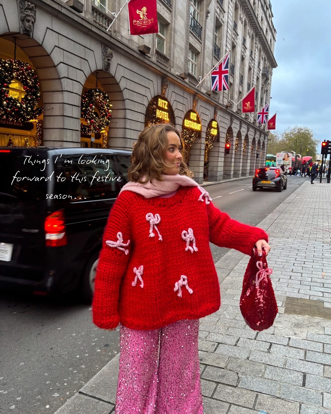 Dressy Christmas sweater outfit with a chunky red bow sweater, sparkling pink sequin wide-leg pants, and a pink scarf.