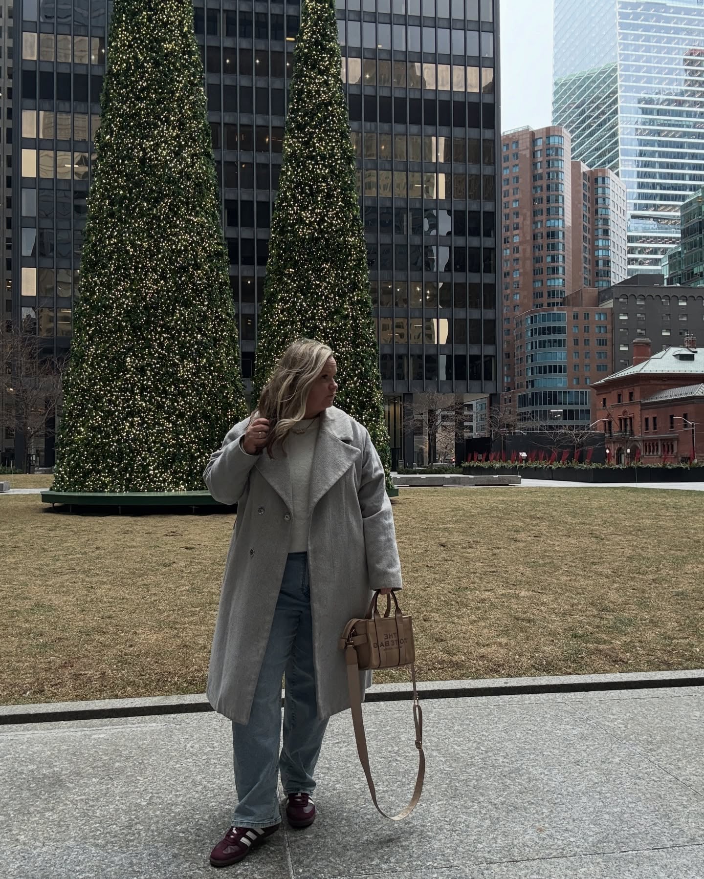 Plus size Christmas outfit with gray coat, sweater, straight-leg jeans and burgundy sneakers