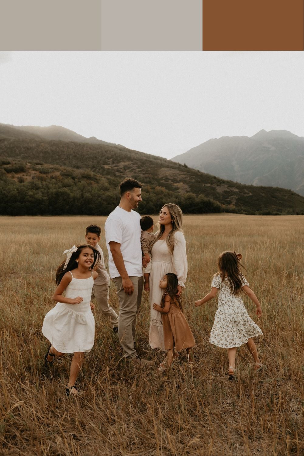 Large family of seven wearing cream, taupe and warm brown outfits in a mountain field for fall family pictures