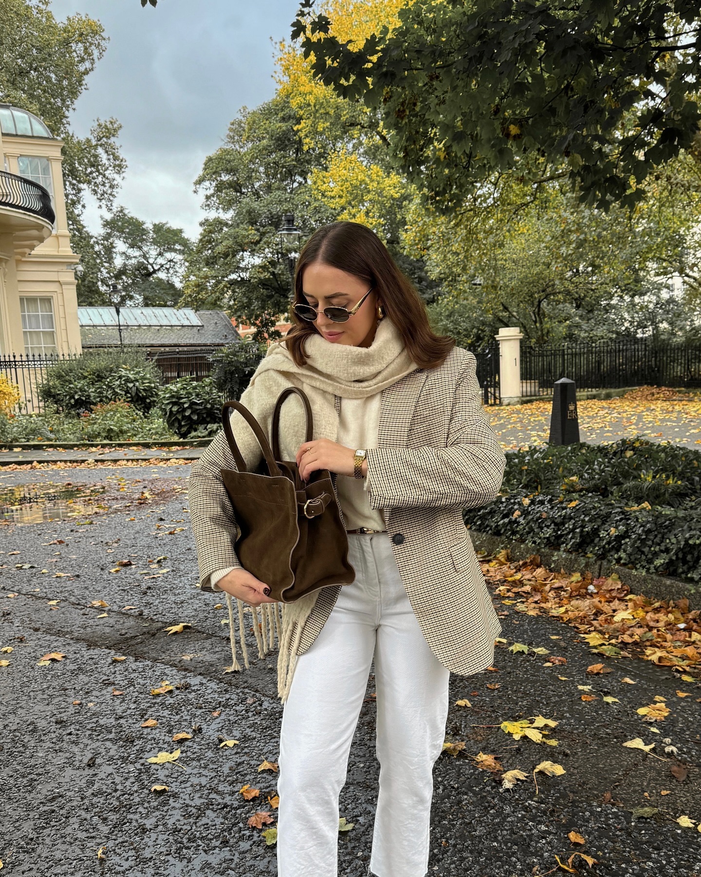 Casual fall outfit for women over 40 with white jeans, plaid blazer, oversized scarf and brown handbag