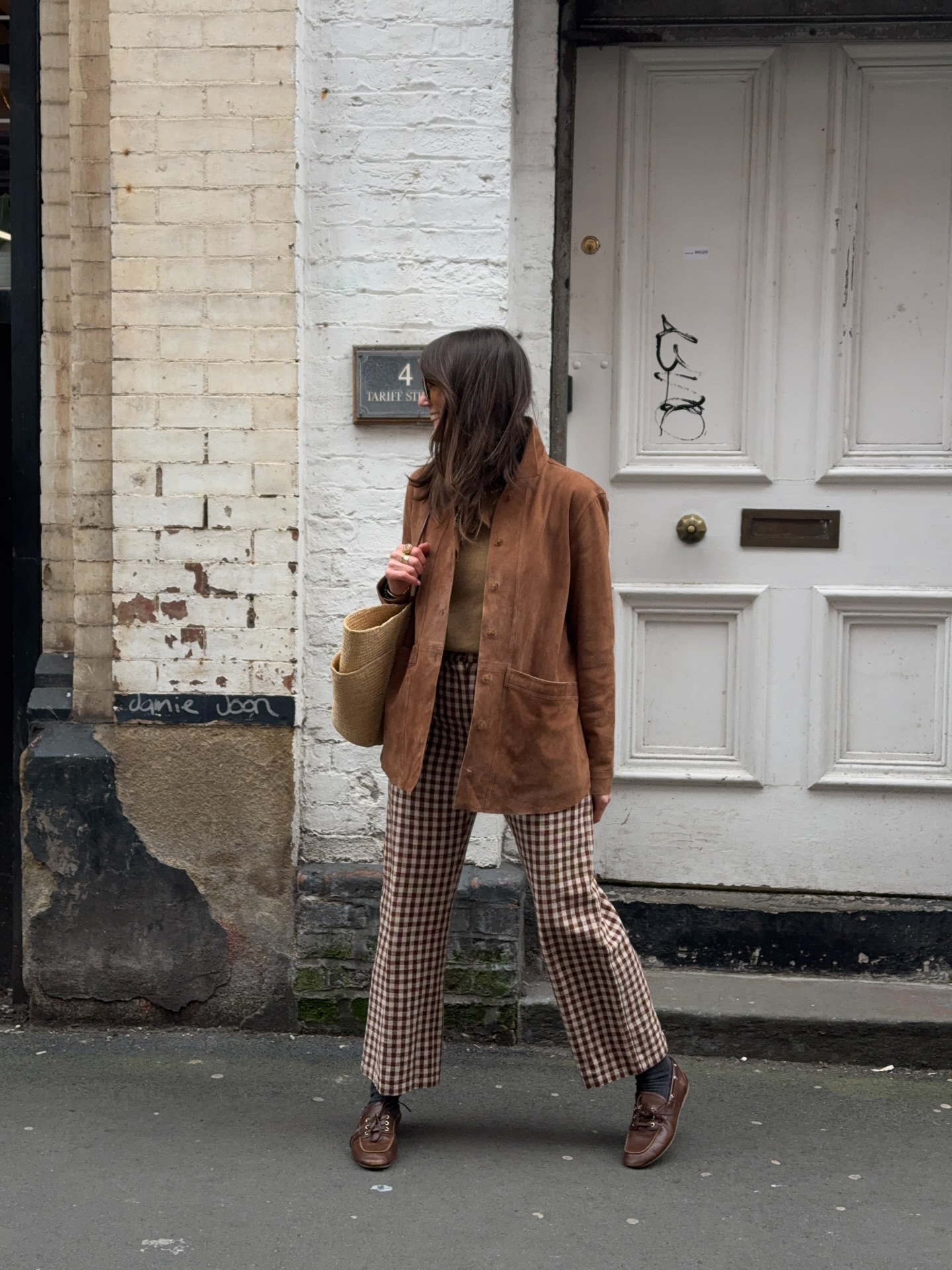 Polished casual fall outfit for women over 40 with checked trousers, brown suede jacket and loafers