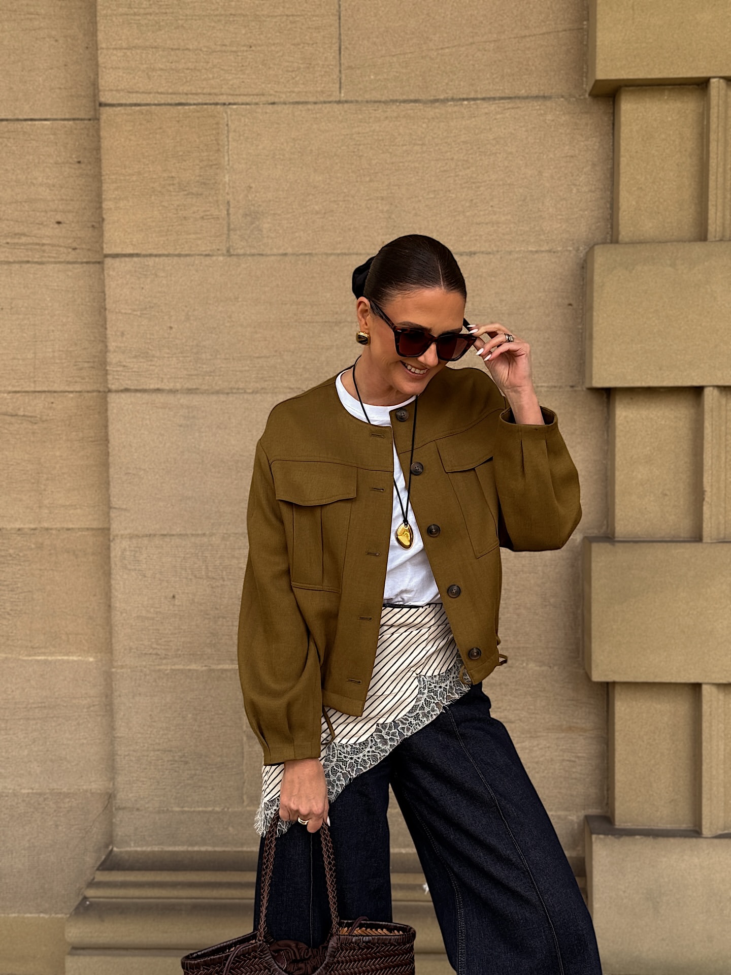 Fall outfit idea for women over 40 with dark wide-leg jeans, white T-shirt and cropped olive jacket