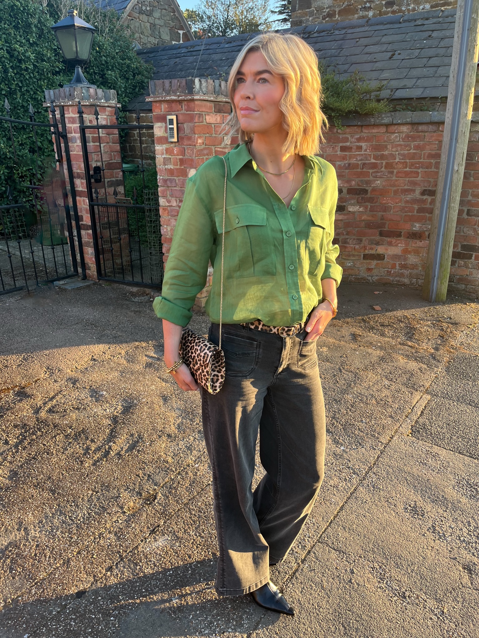 Casual fall outfit for women over 40 with green button-down shirt, charcoal jeans and leopard accessories