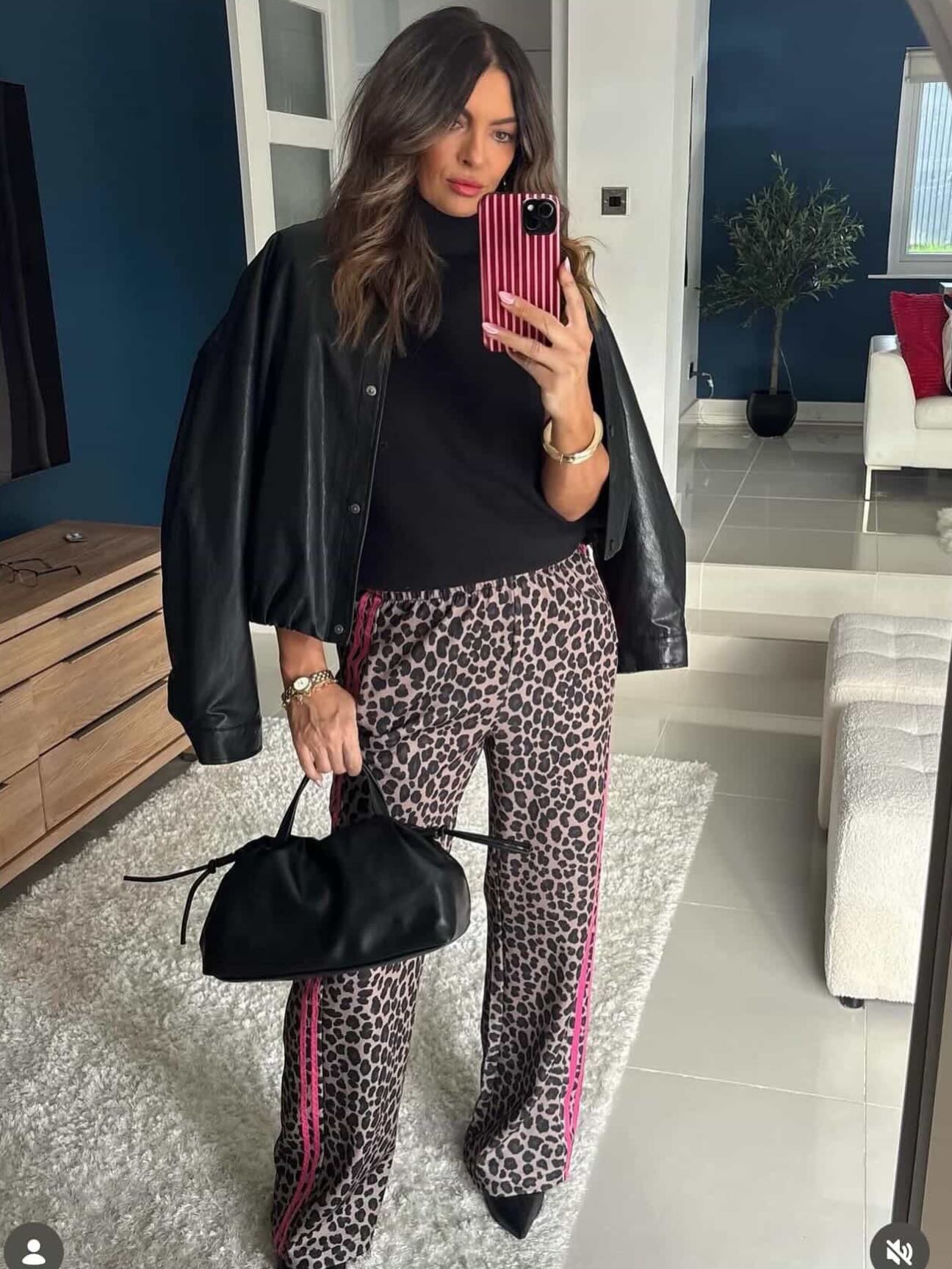 Casual fall outfit idea with leopard-print trousers, black top and black leather jacket